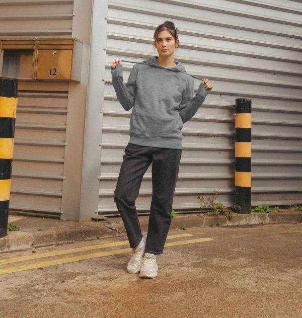 A photo of a woman wearing a light heather coloured hoodie