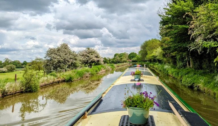 A photo of Narrowboat Round Tuit cruising along a rural canal