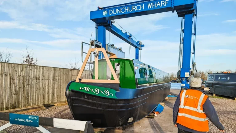 A photo of a narrowboat being lifted into the water
