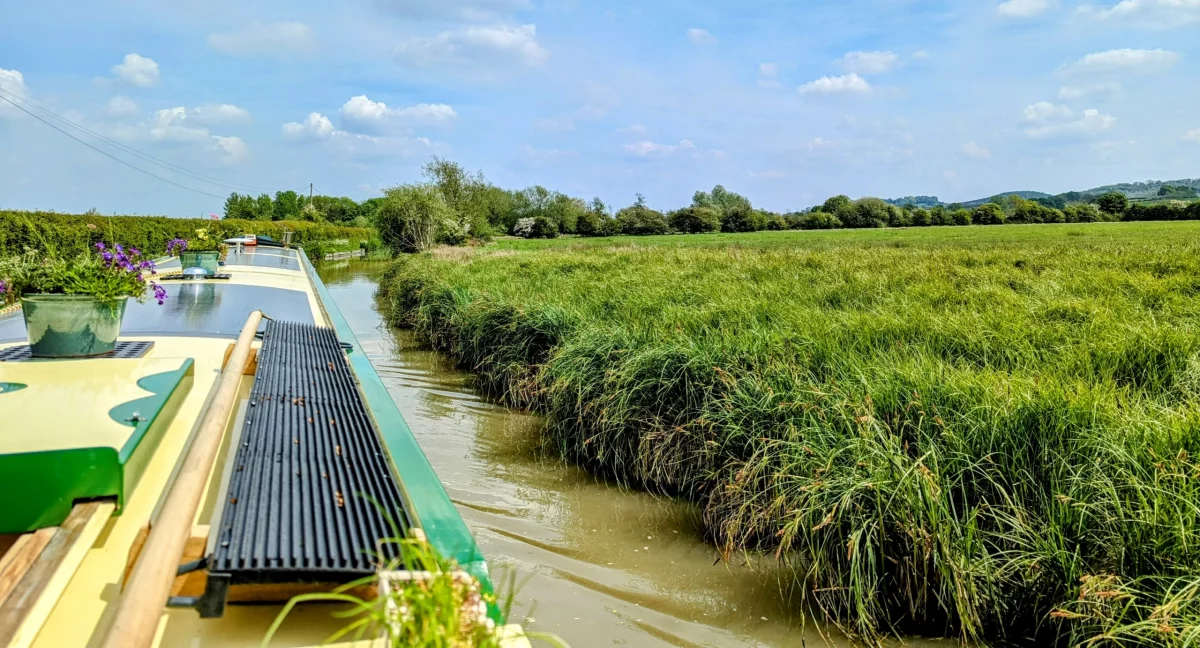 A photo of Narrowboat Round Tuit cruising along a rural canal