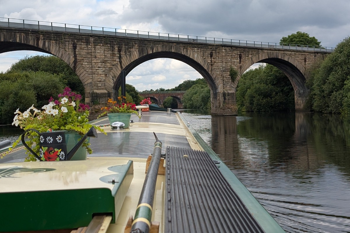 Round Tuit passing beneath an arched bridge on the River Ouse in Yorkshire.