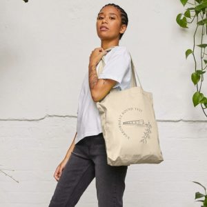 A photo of a woman holding a natural coloured tote bag