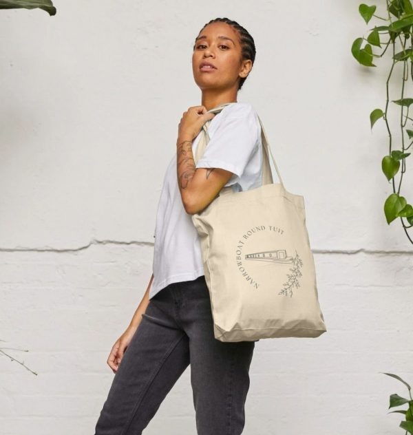 A photo of a woman holding a natural coloured tote bag