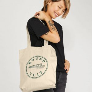 A photo of a woman holding a natural coloured tote bag