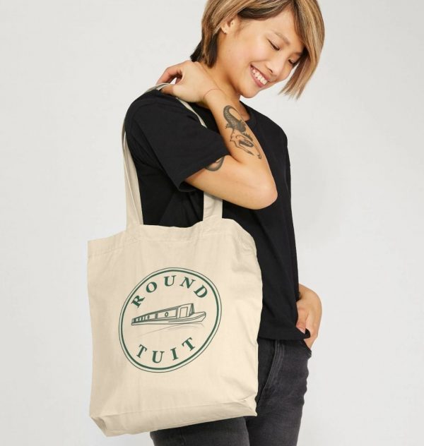 A photo of a woman holding a natural coloured tote bag