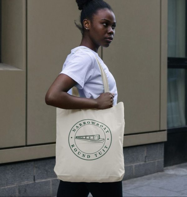 A photo of a woman holding a natural coloured tote bag