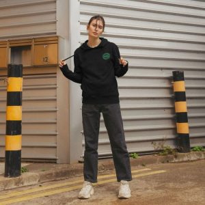 A photo of a woman wearing a black hoodie