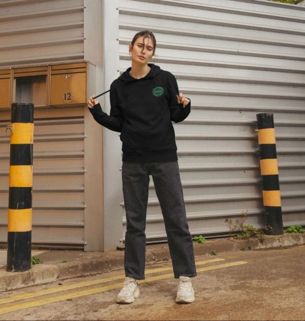 A photo of a woman wearing a black hoodie