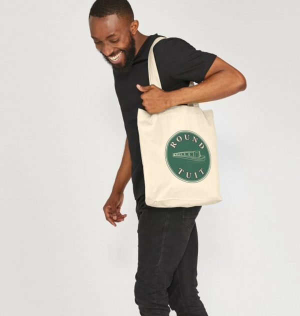 A photo of a man holding a natural coloured tote bag