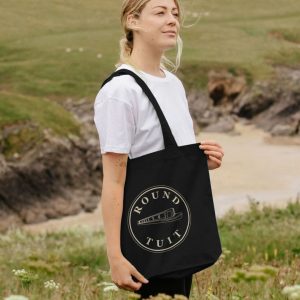 A photo of a woman holding a black tote bag