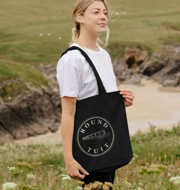 A photo of a woman holding a black tote bag