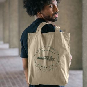 A photo of a man holding a natural coloured tote bag