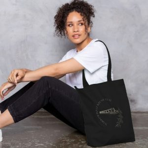 A photo of a woman holding a black tote bag