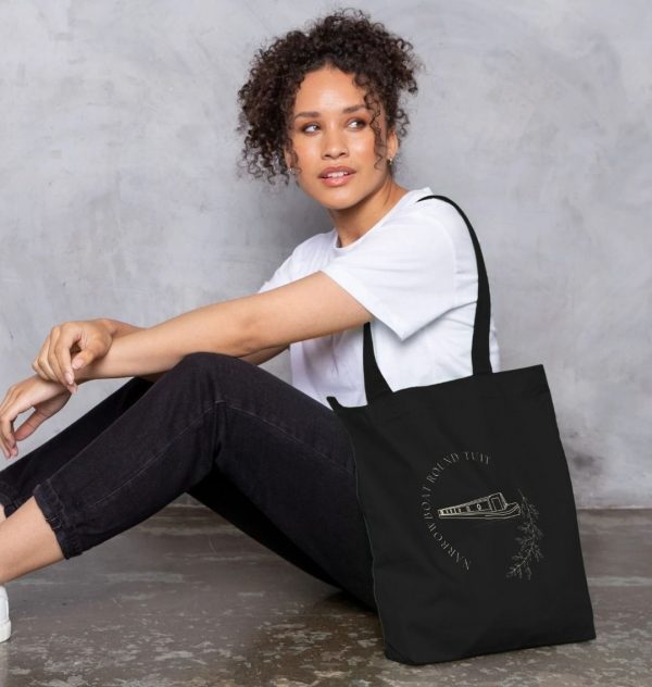 A photo of a woman holding a black tote bag